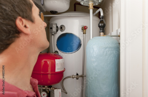 Photo: Plumber looking at central heating boiler Plumber looking at central heating boiler