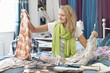 Young woman looking at clothes in bed