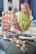 Young woman looking at shirt in bed