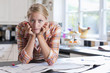 Portrait of young woman with head in hands surrounded by classified ads