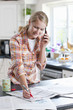 Photo: Smiling young woman talking on cell phone and circling classified ad in newspaper Smiling young woman talking on cell phone and circling classified ad in newspaper