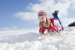 Enthusiastic girl sledding down snowy hill