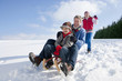 Father and son sledding down snowy hill