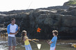 Photo: Daughter and son watching father catch crab with fishing rod in tide pool Daughter and son watching father catch crab with fishing rod in tide pool