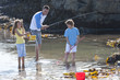 Photo: Father fishing with daughter and son in tide pool Father fishing with daughter and son in tide pool