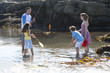 Photo: Family catching crab with fishing rod in tide pool Family catching crab with fishing rod in tide pool