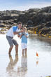 Photo: Father and son catching crab with fishing rod in tide pool Father and son catching crab with fishing rod in tide pool