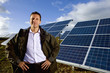 Portrait of smiling farmer standing in front of solar panels