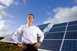 Portrait of smiling man standing in front of solar panels