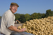 Foto: Portrait of smiling farmer inspecting potatoes from trailer in sunny, rural field Portrait of smiling farmer inspecting potatoes from trailer in sunny, rural field