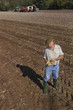 Foto: Farmer inspecting potatoes in sunny, rural field Farmer inspecting potatoes in sunny, rural field