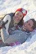 Portrait of smiling couple laying in snow