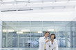 Engineers in lab coats examining part in office