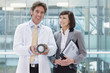 Photo: Portrait of smiling engineer and businesswoman with part in office Portrait of smiling engineer and businesswoman with part in office