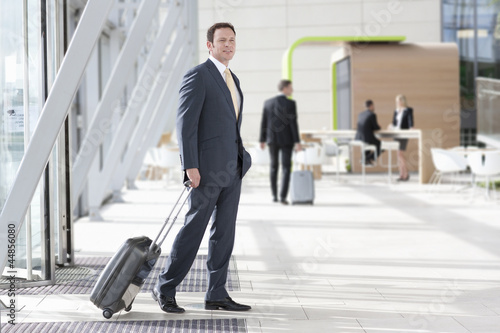 Photo: Businessman with suitcase arriving at airport Businessman with suitcase arriving at airport