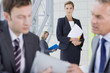 Portrait of smiling businesswoman in suit holding file in lobby