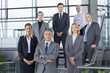 Portrait of confident business people in suits standing on steps