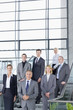 Portrait of smiling business people in suits standing on steps