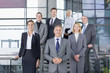 Portrait of smiling business people in suits standing on steps