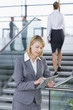 Businesswoman in suit using digital tablet in lobby