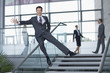 Portrait of enthusiastic businessman in suit sliding down railing in lobby