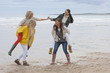 Smiling young women in piggyback battle on beach