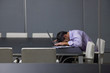 Businessman sleeping on laptop in conference room