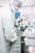 Scientists in clean suits working in silicon wafer manufacturing laboratory