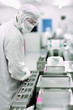 Photo: Scientist in clean suit watching silicon wafers being processed in clean room laboratory Scientist in clean suit watching silicon wafers being processed in clean room laboratory