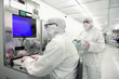 Foto: Scientist in clean suit working at computer in silicon wafer manufacturing clean room Scientist in clean suit working at computer in silicon wafer manufacturing clean room
