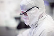 Photo: Close up of scientist in clean suit of silicon wafer manufacturing laboratory Close up of scientist in clean suit of silicon wafer manufacturing laboratory