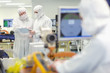 Photo: Scientists in clean suits discussing paperwork in silicon wafer manufacturing laboratory Scientists in clean suits discussing paperwork in silicon wafer manufacturing laboratory