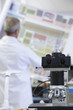 Photo: Engineer examining circuit diagram in laboratory with telescope in foreground Engineer examining circuit diagram in laboratory with telescope in foreground