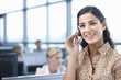 Brunette businesswoman talking into headset in office