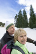 Close up of happy senior couple backpacking in snowy woods