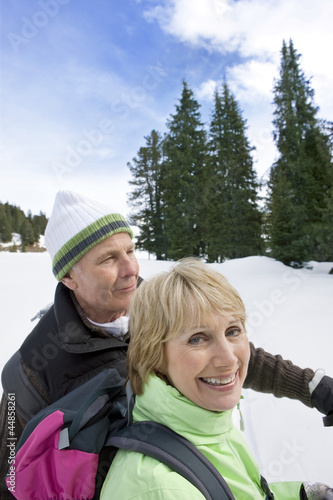 Photo: Close up of happy senior couple backpacking in snowy woods Close up of happy senior couple backpacking in snowy woods