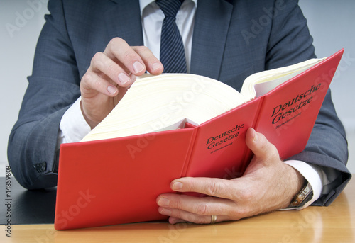Photo: Notar oder Anwalt liest im Deutschen Gesetzbuch Notar oder Anwalt liest im Deutschen Gesetzbuch