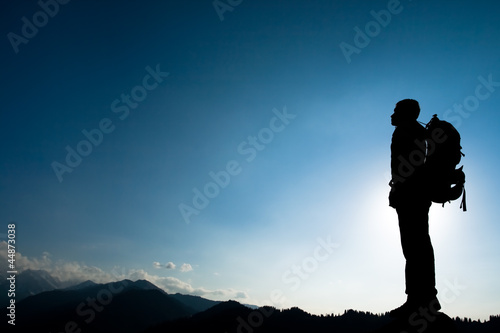 Photo: Silhouette of climbing young adult at the top of summit Silhouette of climbing young adult at the top of summit