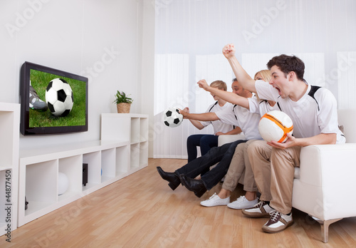 Photo: Jubilant family watching television Jubilant family watching television