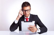 man contemplating at what he is reading on pad
