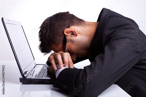 Photo: Tired business man sleeping on laptop Tired business man sleeping on laptop