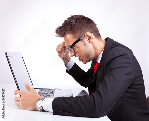 Photo: angry business man at his laptop angry business man at his laptop