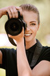 smiling young woman photographs on camera