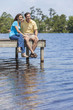 Photo: Romantic Man and Woman Couple Sitting By Lake Romantic Man and Woman Couple Sitting By Lake