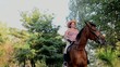 Young girl in the forest riding a horse