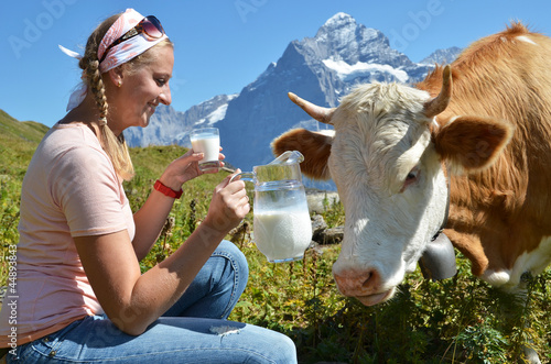 Photo: Girl with a jug of milk and a cow. Switzerland Girl with a jug of milk and a cow. Switzerland