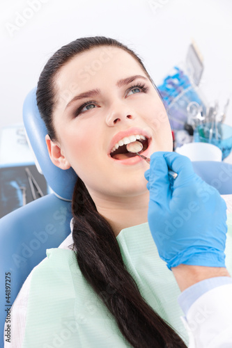 Photo: Dentist is looking for the defects in the oral cavity Dentist is looking for the defects in the oral cavity