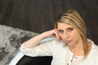 Blond woman sitting on a sofa