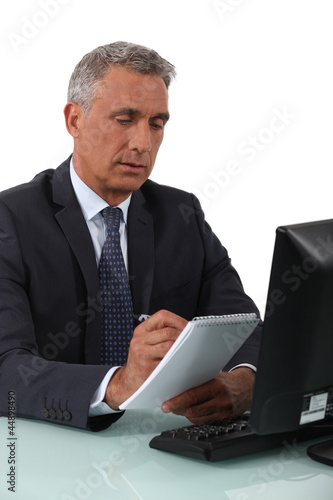 Photo: Businessman writing in a notebook Businessman writing in a notebook