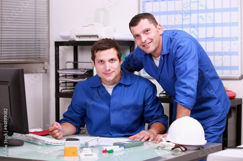Photo: two technicians working in office two technicians working in office